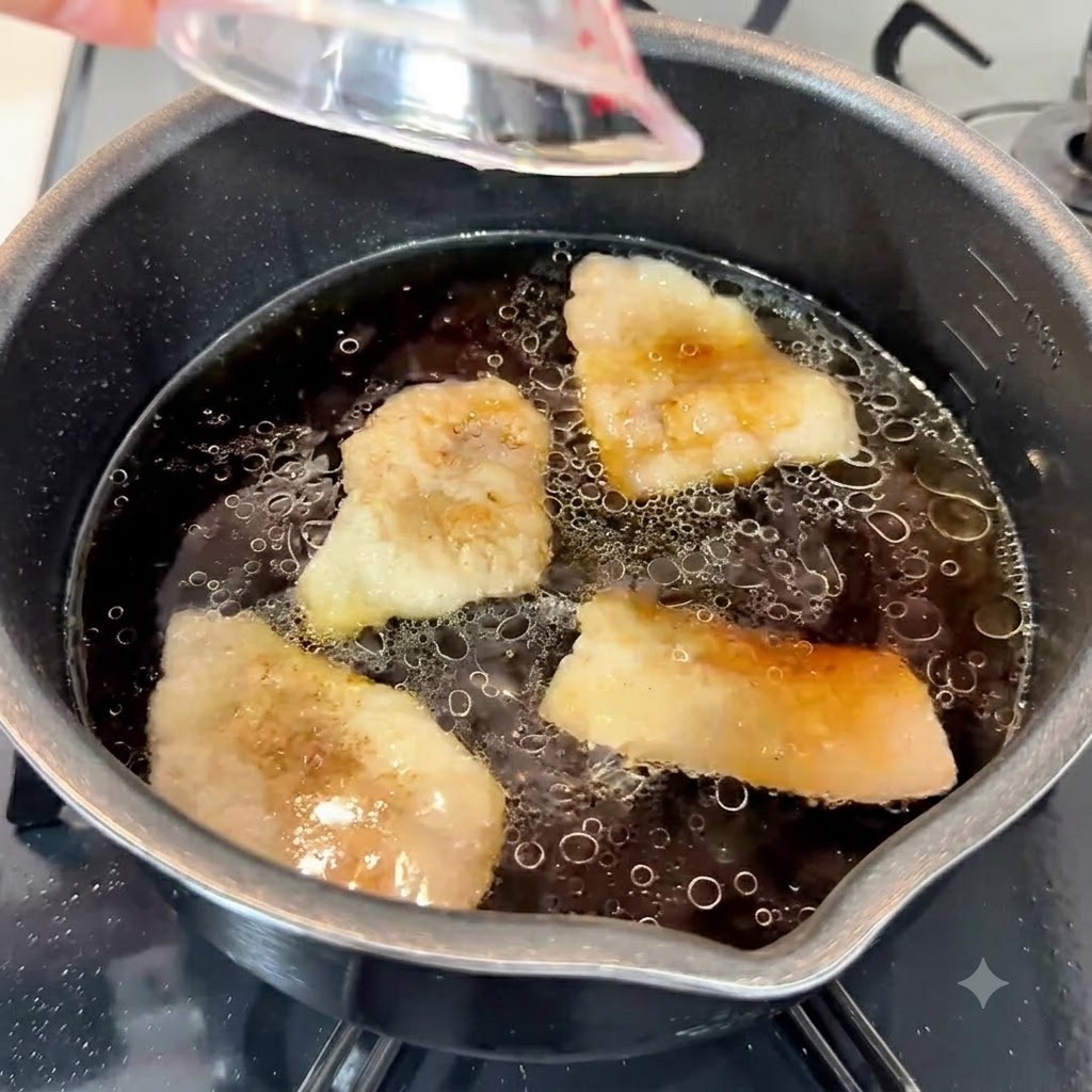 냄비 속 진한 육수에 다진 마늘, 참기름, 설탕이 들어가고 있는 모습.