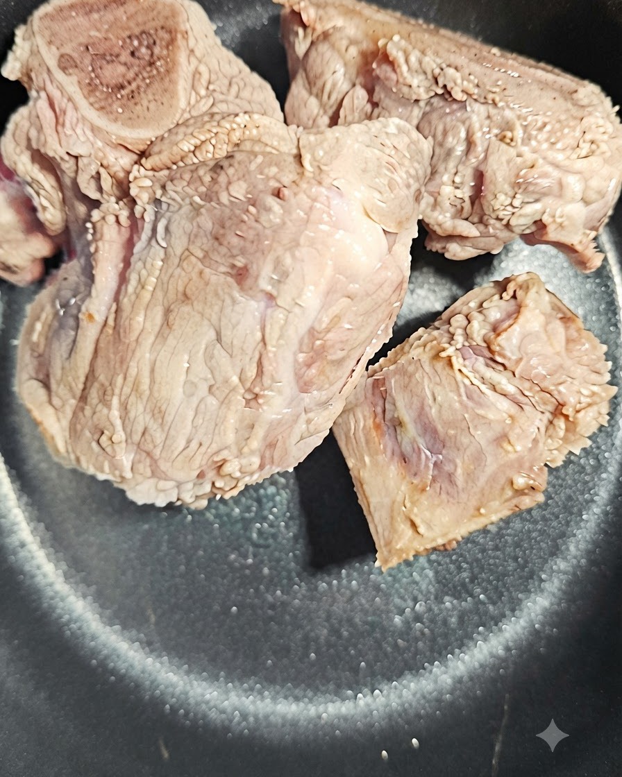 밥솥 안의 돼지 뼈 옆에 놓인 당귀 편 한 조각