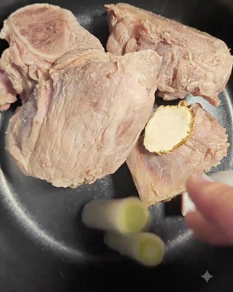 뼈와 당귀가 담긴 밥솥에 넣는 대파 흰 부분 두 조각