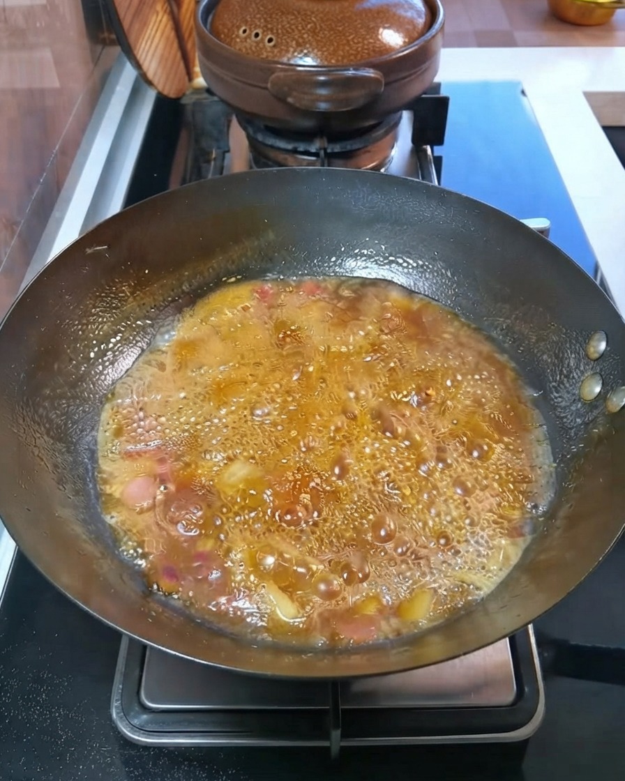 웍 안에서 끓고 있는 육수 속에서 깍둑썰기 한 감자와 당근이 보글보글 익어가는 모습.