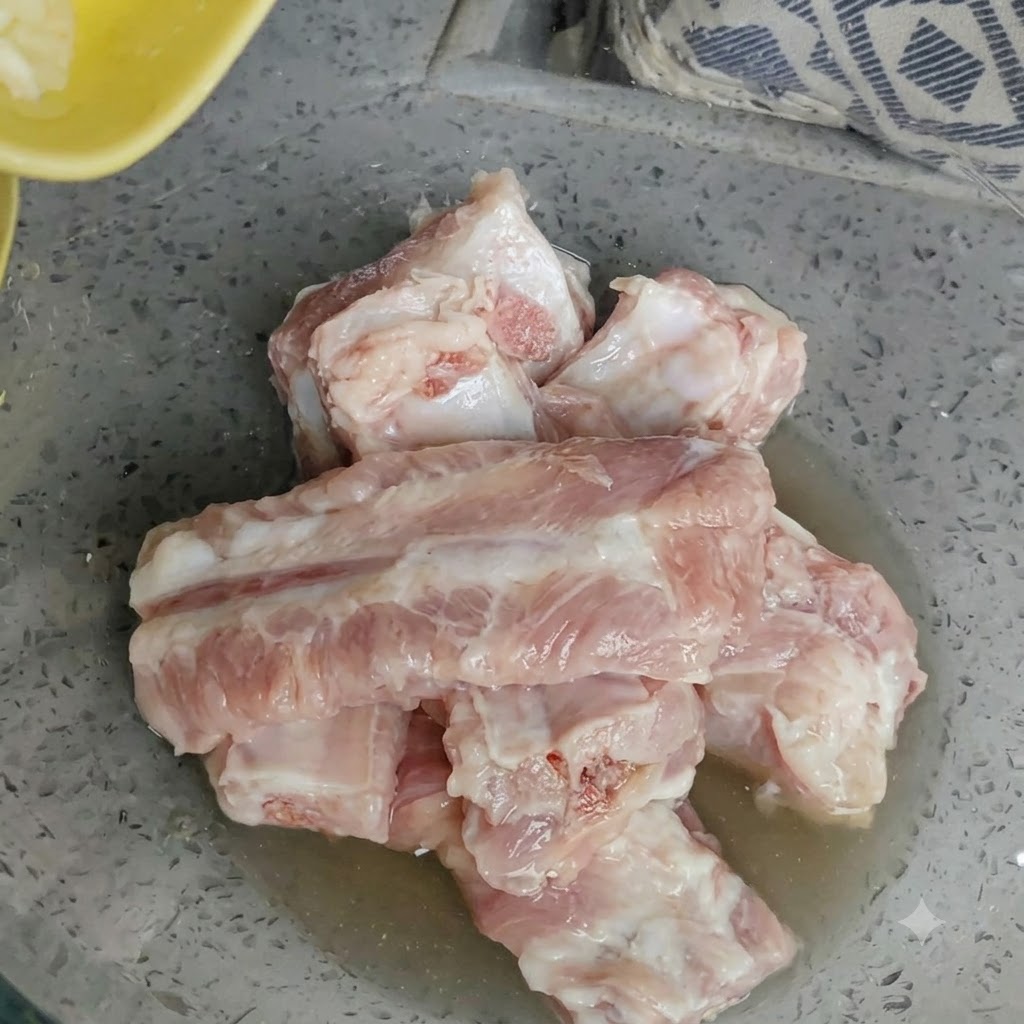 생돼지갈비와 레몬즙이 담긴 볼에 곱게 다진 마늘이 얹어져 있는 모습.