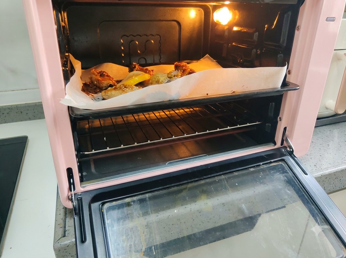 굽고 있는 돼지갈비 옆 베이킹 시트에 신선한 레몬 슬라이스가 놓여 있는 모습.