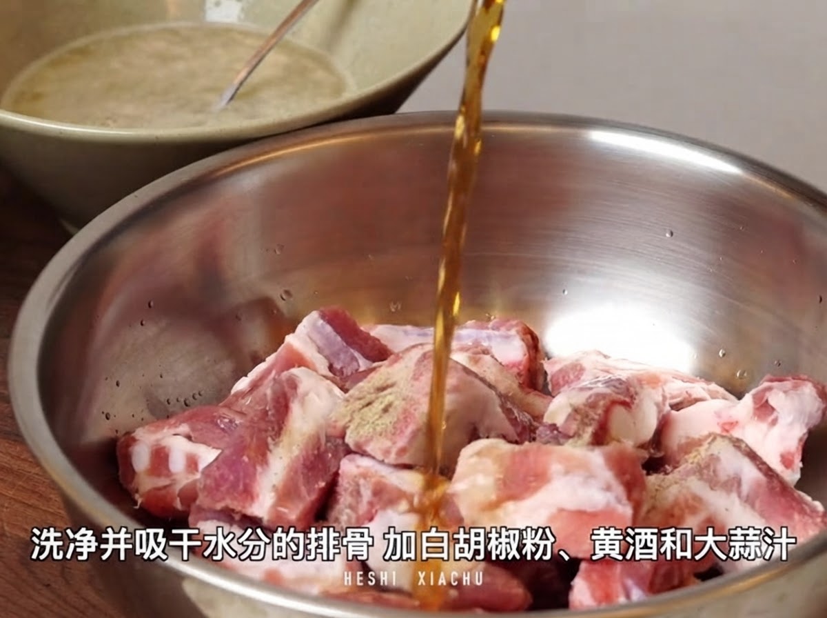 백후추 가루가 뿌려진 손질된 돼지갈비가 담긴 금속 볼 위로 황주가 부어지는 모습.