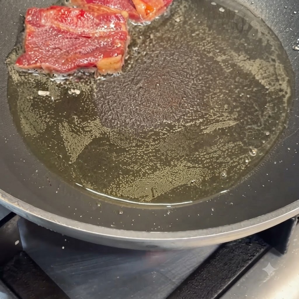 뜨겁게 달군 프라이팬에서 기름에 구워지고 있는 양념된 소갈비.