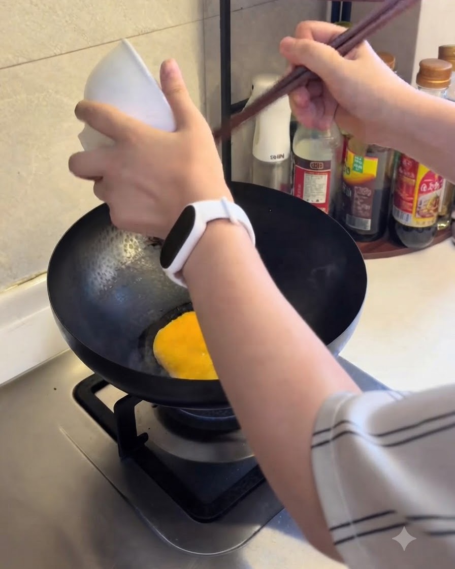 달궈진 팬에 푼 계란을 부어 익히는 모습.
