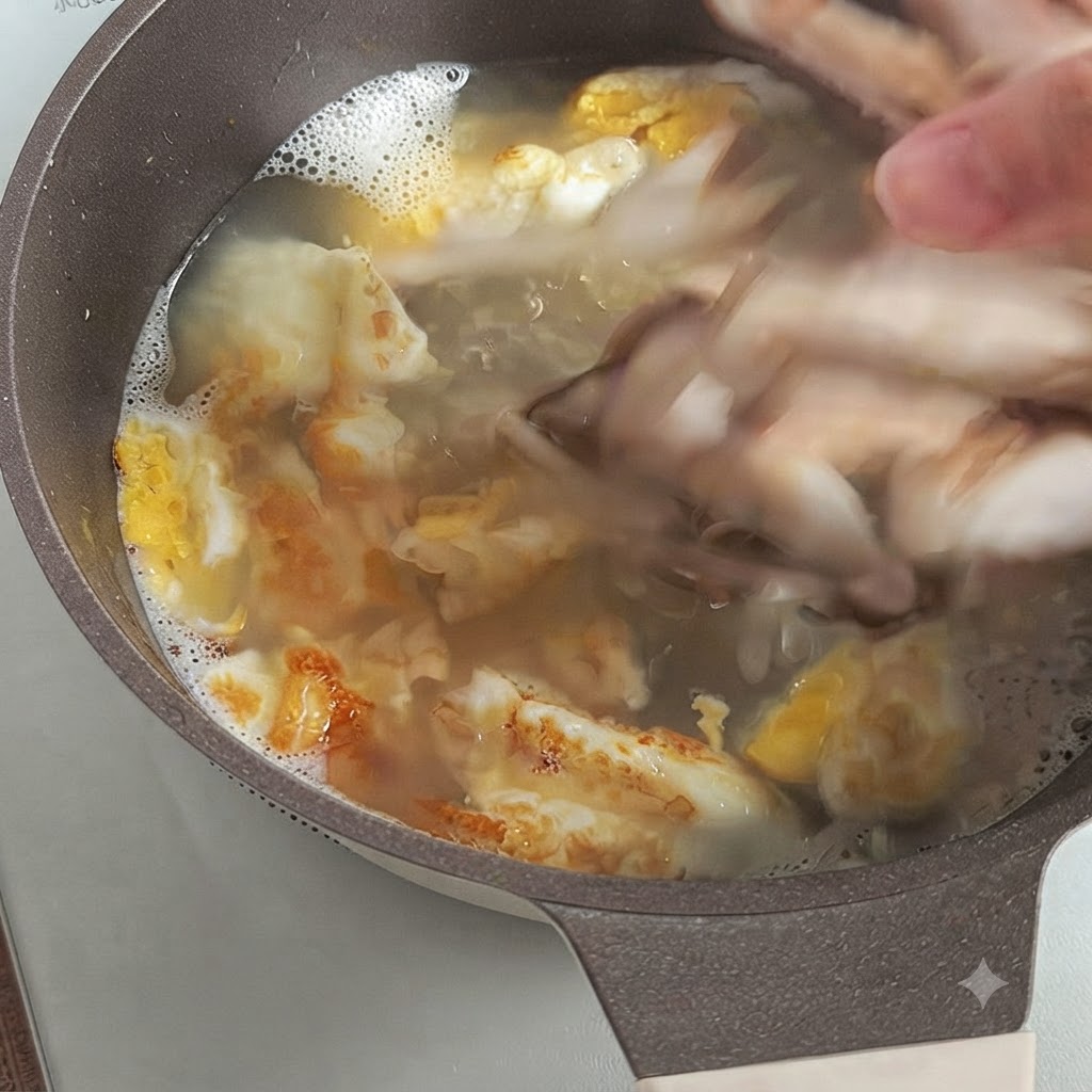 구운 달걀 조각이 있는 끓는 육수에 썬 표고버섯을 넣는 손.