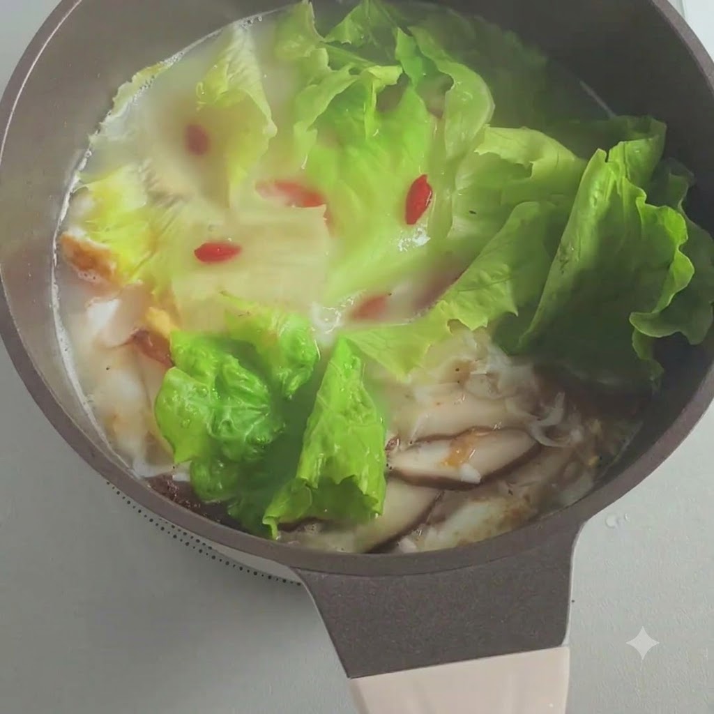 끓고 있는 국물 냄비에 다진 대파가 뿌려지는 모습.