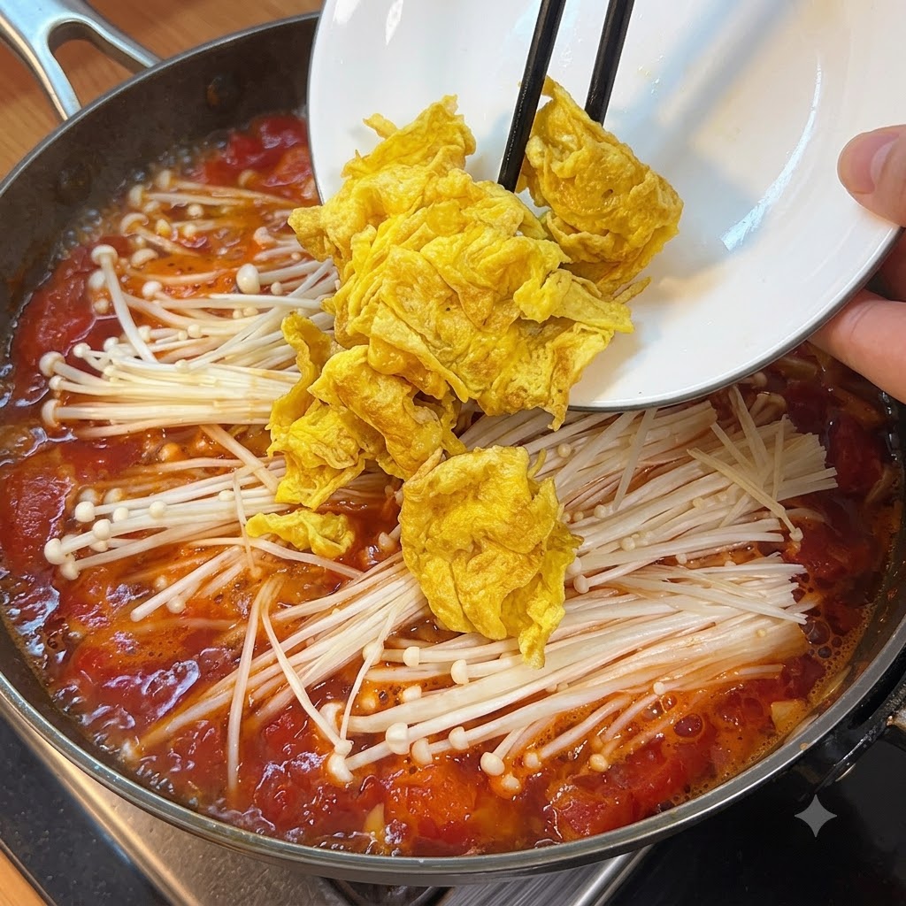 토마토와 버섯이 끓고 있는 냄비에 썰어둔 연두부를 넣는 모습.