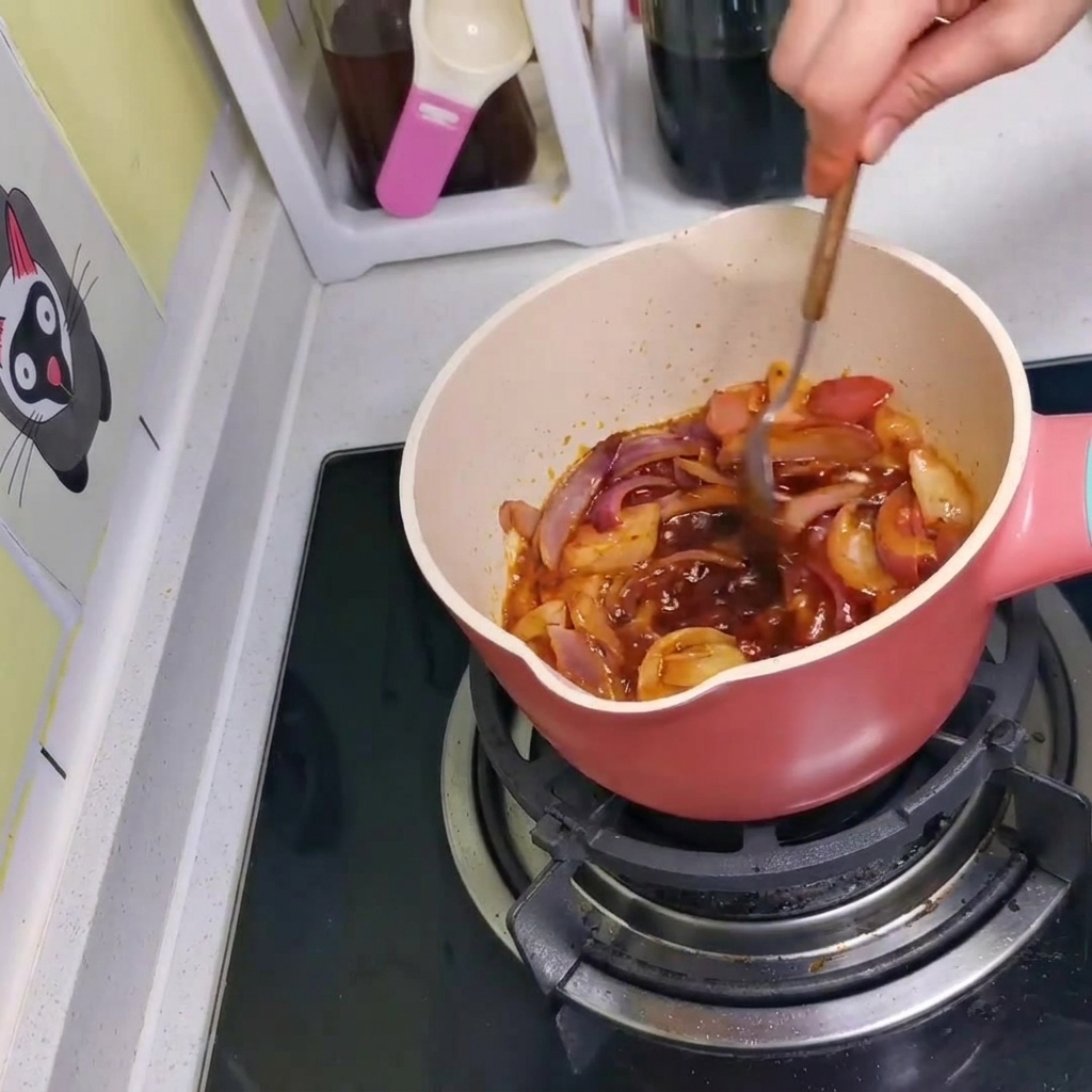 숟가락으로 냄비 안의 양념, 양파, 김치를 골고루 섞는 모습