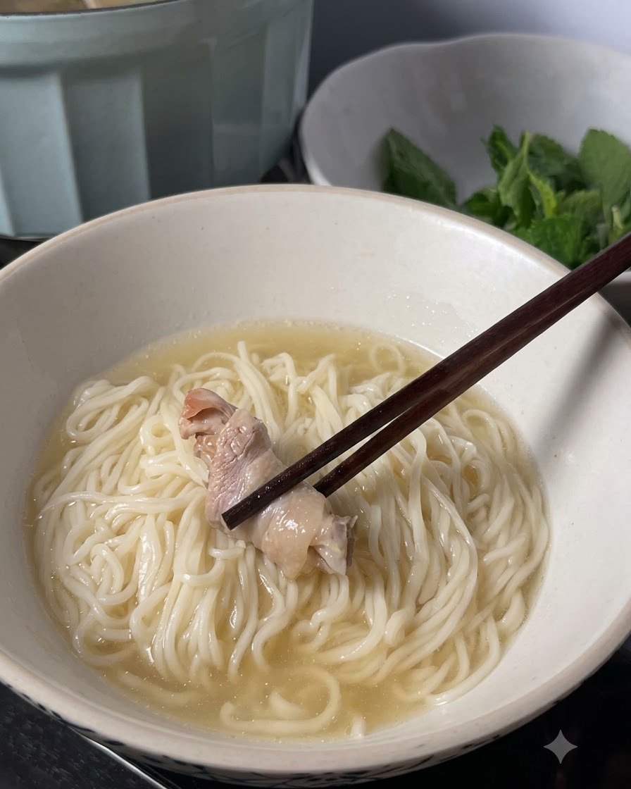 젓가락이 육수가 부어진 면 위에 익힌 닭고기 한 조각을 올려놓는 모습.